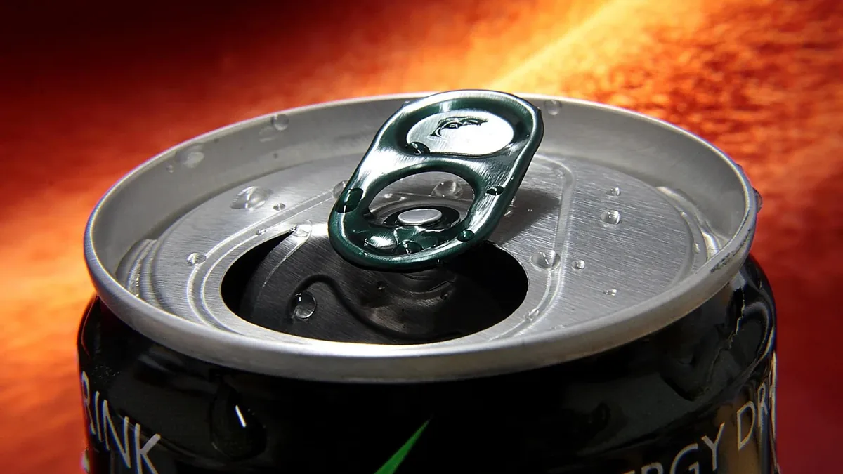 A can of energy drink with the top open and the pull tab removed.